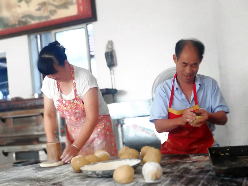 江塘乡毕岭村王茂胜夫妇正在制作民间传统手工月饼，并送与邻居品尝。.jpg